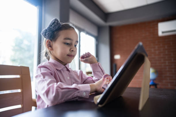 istock Child Girl Playing Video Game Using Digital Tablet At Home 1456782582