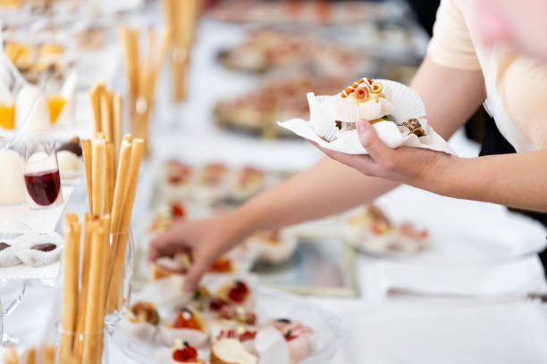 istock Man hands holding plate and picking up canapes appetizers from buffet table on event. 1456783756