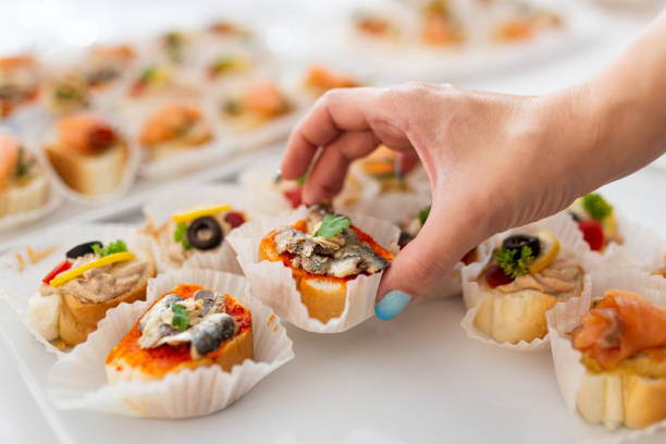 Close up of female hand holding canape. Buffet meal event concept.
