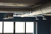 Silver ventilation pipes hanging from the ceiling inside the building