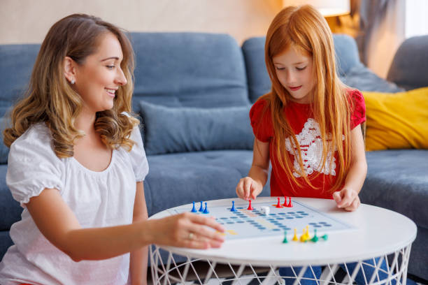 istock Mother and daughter having fun playing ludo board game at home 1456785809