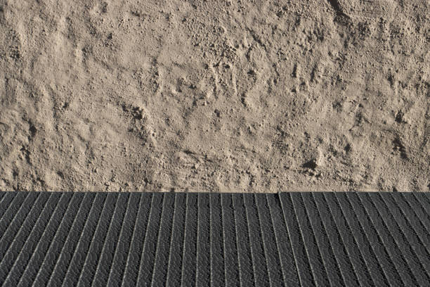 Metal grid floor in front of a grey wall with focus on the wall
