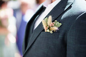 a dried flower boutonniere in the pocket of a man's jacket.