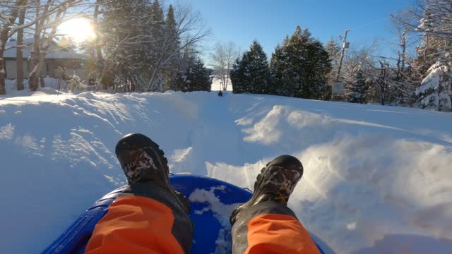 POV of Man Sledding Outdoors on the Snow in Winter at Sunset in Quebec, Canada