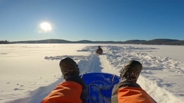 POV of Man Sledding Outdoors on the Snow in Winter at Sunset in Quebec, Canada