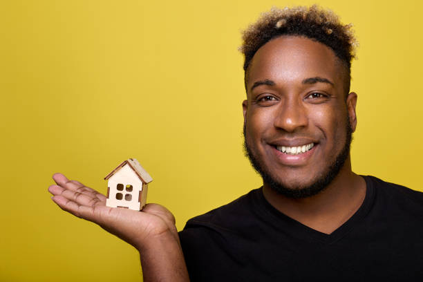 istock Curly African-American demonstrates a house construction set in his hand 1456793369