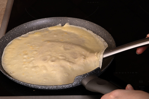 photo preparation of thin round pancakes on the stove