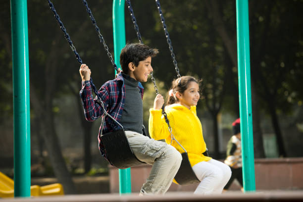 Happy brother and sister playing outdoors at park