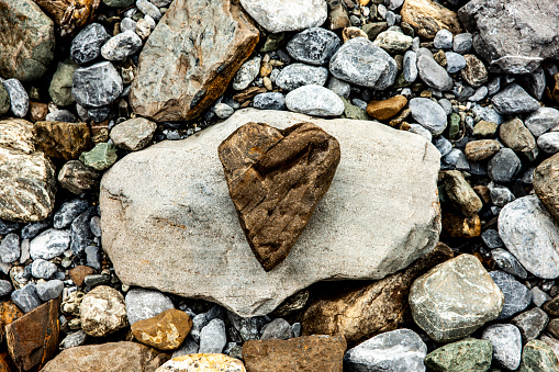 Stone heart on a rock with pebbles