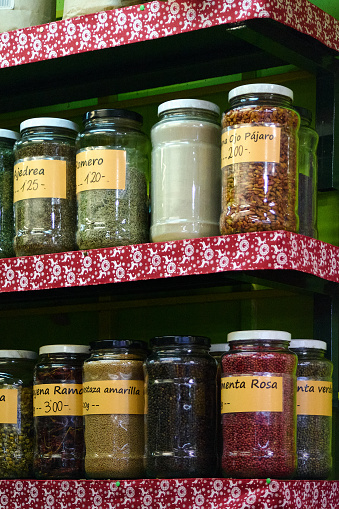 Spices on a shelf in the pantry with the name that identifies them.
