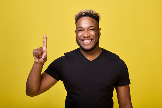 istock On a yellow background stands a popular black guy with a smile on his face 1456796024
