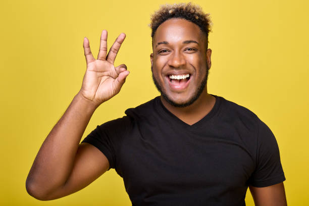 istock Dark-skinned smiling man makes a sign ok with his fingers 1456797979