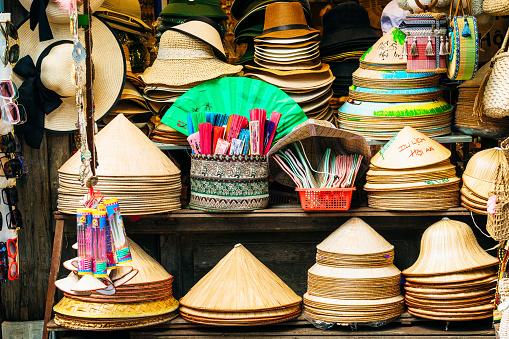 Straw hats for sale on the stalls of a shophouse in Hoi An, Vietnam