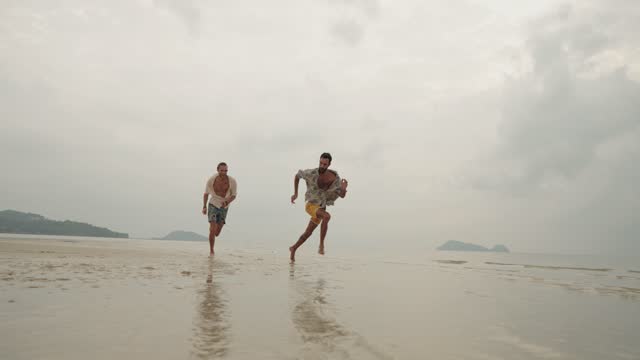 Joyful couple running on the beach