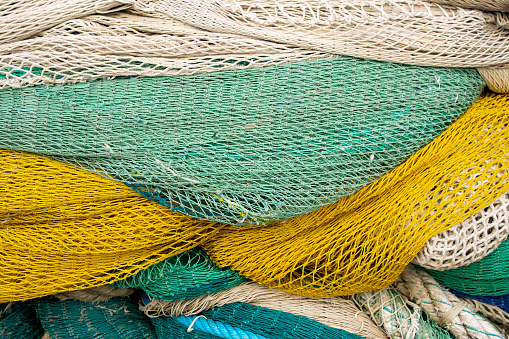 Detail of fishing nets drying in the sun, white, yellowand green.