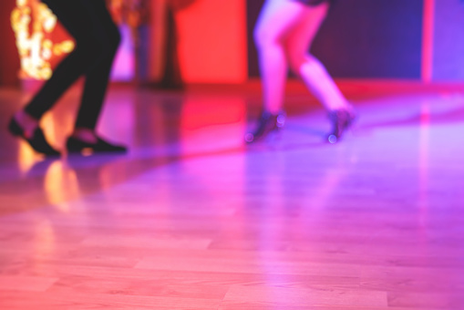 Young couple disco dancing at the retro roller skating rink.