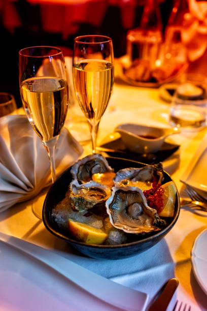 istock Oysters and wine. Romantic dinner table for two, restaurante. Dark evening background, vertical image. Selective focus. 1456806170