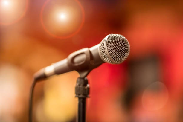 istock Microphone on stage against a background of auditorium. 1456809629