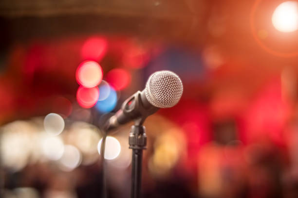 istock Microphone on stage against a background of auditorium. 1456809651