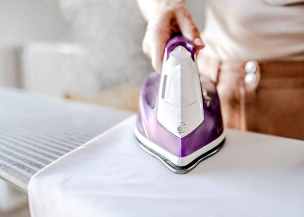 istock Girl hand using iron for wrinkled clothes 1456810851