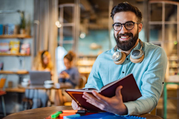 istock Men holding a book in university cafe 1456811204