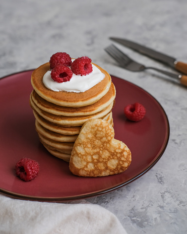 Pancakes with sour cream and raspberries. Breakfast for Valentine's Day