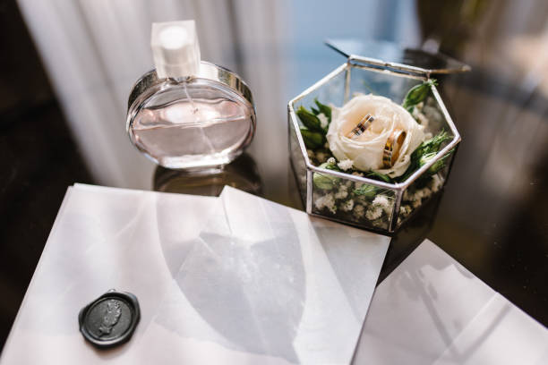 istock Wedding accessory bride. Gold rings in box, flowers, perfumes on table. Letters from the bride and groom. Vows. flat lay. top view. 1456811972