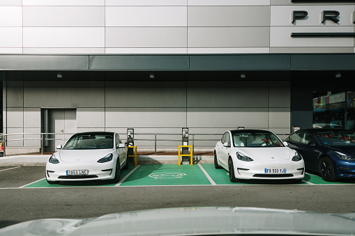 Santander, Spain - 12 January 2023: Tesla cars stationary in special parking spots for electric cars in a parking lot in Santander, Spain