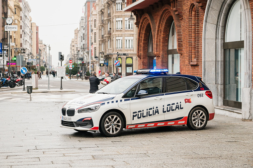 León, Spain - 14 January 2023: A city police BMW 2 series electric car in a street of León, Spain