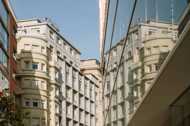 View of old and renovated facades of a street in Vienna, 1st district. The opposite houses are reflected in a modern shop window.