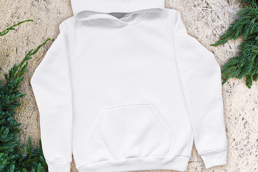 White fashionable sweatshirt with a hood with clothes hanger on golden background top view. Unisex clothing, hoodie, casual youth style, sports. Blank hoody flatlay Christmas mock up