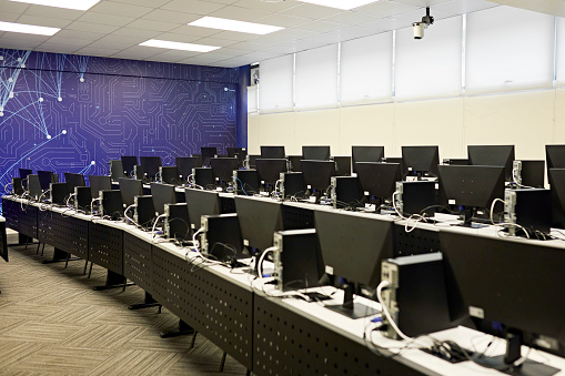 Tiered rows of desktop pcs side by side and ready for student use. Property release attached.