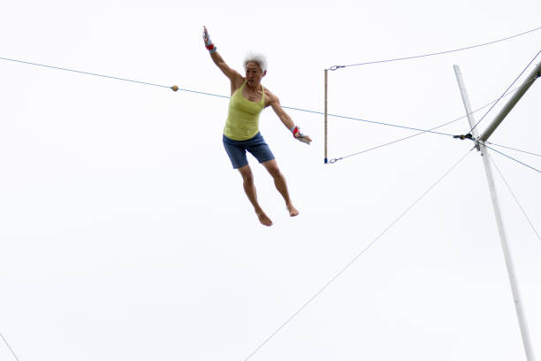 Mature trapeze artist flying in the sky
