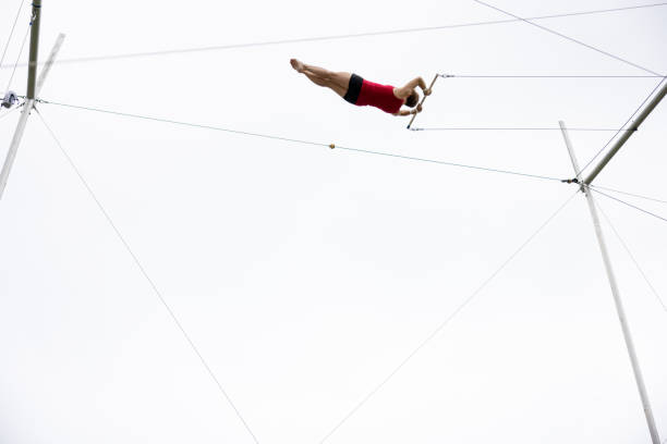 Mature trapeze artist flying in the sky