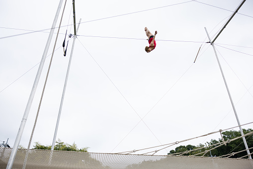 Mature trapeze artist flying in the sky