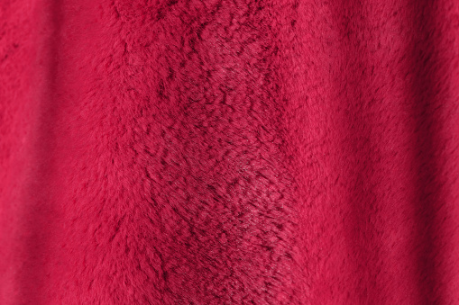 Red delicate soft background of plush fabric. Viva Magenta color decor