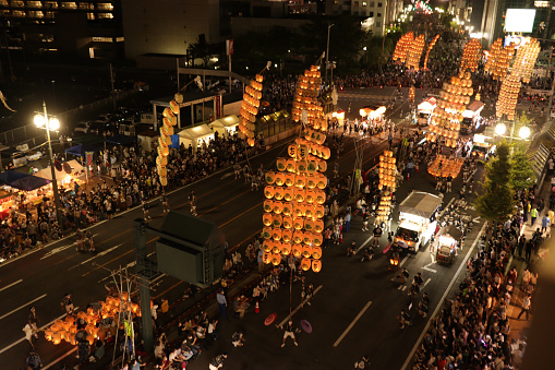 AKITA, JAPAN - AUGUST 6: People watch the Kanto lanterns being carried during the Akita Kanto Festival on August 6, 2022 in Akita, Japan. Akita Kanto Festival is a summer festival held from August 3 to 6 in Akita City, Akita Prefecture. It is considered one of the three major festivals in Tohoku. It was the first time after three years that the festival was held due to the COVID-19 pandemic.
