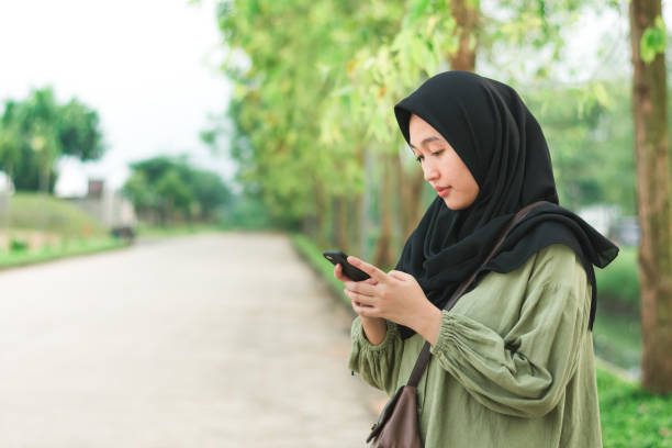 istock Beautiful Asian woman in hijab using a smartphone 1456820065