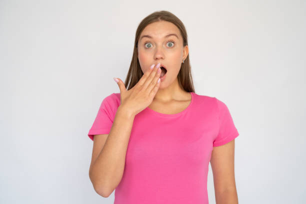 shocked young woman covering mouth - gasping imagens e fotografias de stock