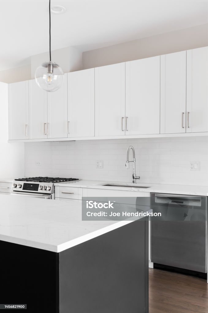 Una Cocina Moderna Con Gabinetes Blancos Isla Negra Y Electrodomésticos De  Acero Inoxidable Foto de stock y más banco de imágenes de Acero - iStock