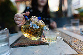 Woman filling cup with hot tea