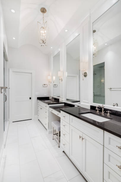 istock A large bathroom with white cabinets, black countertop, and walk-in shower. 1456822672