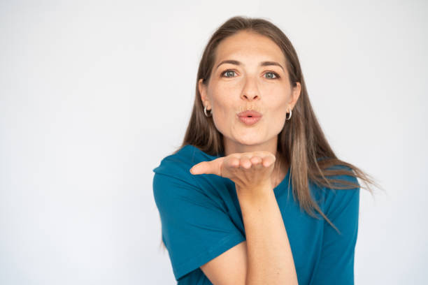 zadowolona kobieta rasy kaukaskiej pocałunek - kissing blowing a kiss blowing women zdjęcia i obrazy z banku zdjęć