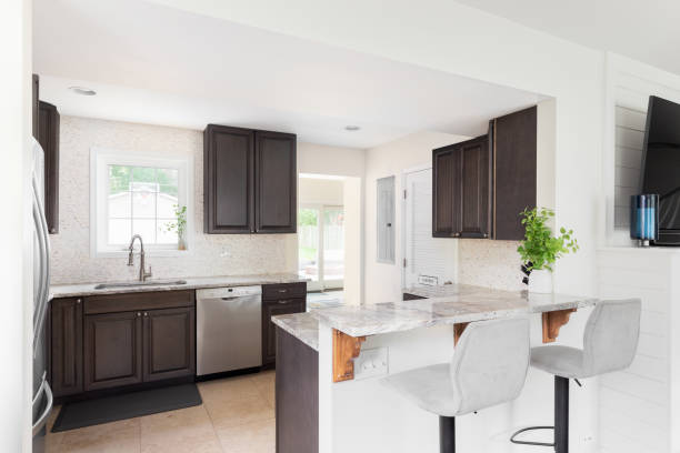 istock A kitchen with wood cabinets and chairs sitting at the countertop. 1456822995