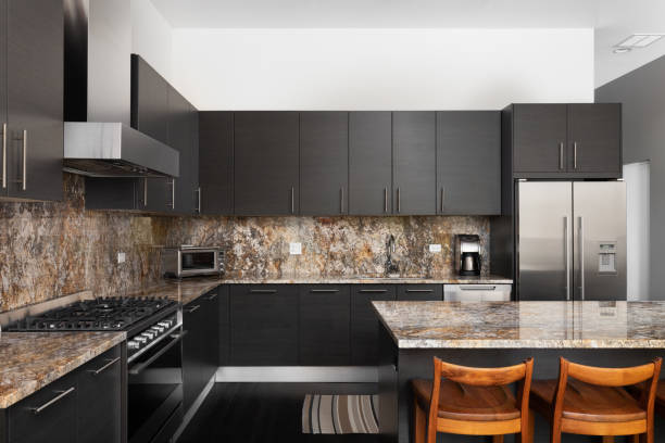 istock A kitchen with dark wood cabinets and chairs sitting at the island. 1456823049