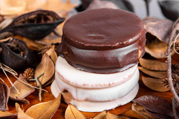 "alfajor", "alfajores", dolci tipici dell'argentina. si tratta di due biscotti dolci ripieni di caramello al latte, e ricoperti, uno di cioccolato bianco, e l'altro di cioccolato fondente, in questo caso. - chocolate dipped flash foto e immagini stock