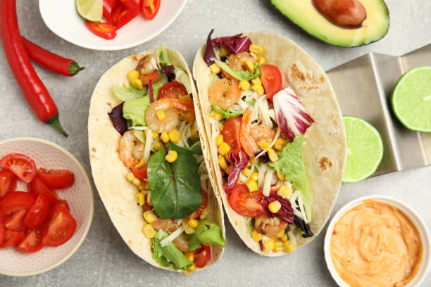 istock Delicious tacos with shrimps served on light grey table, flat lay 1456825073