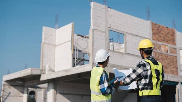 istock Structural engineer and architect working with blueprints discuss at the outdoors construction site. 1456825110