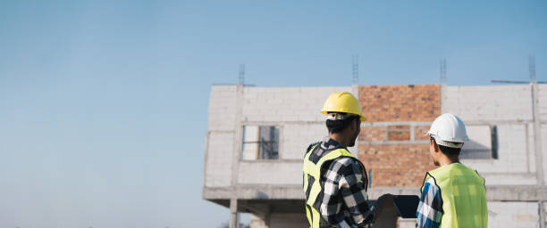 istock Structural engineer and architect working with blueprints discuss at the outdoors construction site. 1456825359
