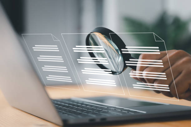 istock A man inspects paper with a magnifying lens. Business analysis, auditing, professional document review, inquiry, and inspection are all concepts. 1456825393